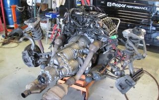 Car engine and suspension assembly in garage workshop