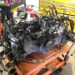 Car engine on workshop cart with tools