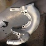 Silver automotive turbocharger housing on workbench