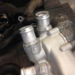 Welded aluminum automotive intake manifold on workbench