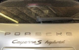 Rear view of dusty Porsche Cayenne S Hybrid