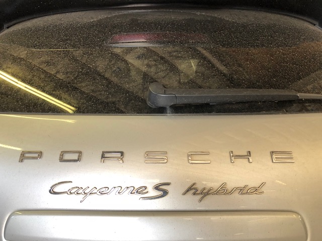 Rear view of dusty Porsche Cayenne S Hybrid