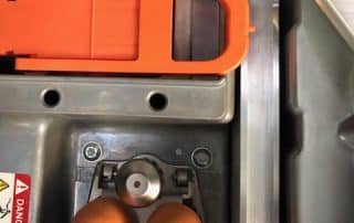 Close-up of industrial machine with orange cables