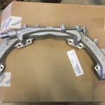 Silver automotive intake manifold on cardboard surface