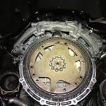 Exposed car engine flywheel during transmission repair
