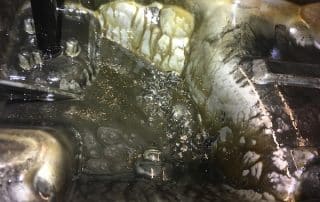 Dirty industrial sink with murky water buildup