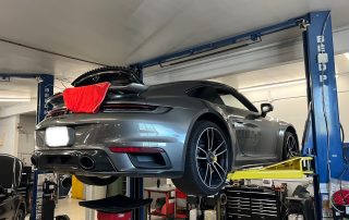 Gray Porsche 911 on car lift