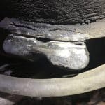 Worn automotive ball joint with torn rubber boot