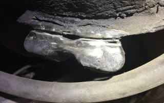 Worn automotive ball joint with torn rubber boot
