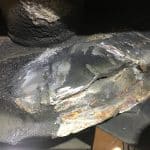 Cracked and corroded metal pipe joint close-up
