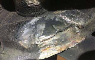Cracked and corroded metal pipe joint close-up