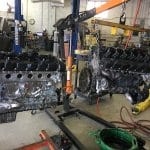 Two car engines suspended in auto repair shop
