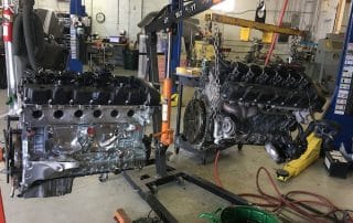 Two car engines suspended in auto repair shop