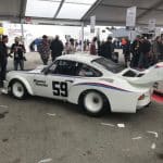 Vintage white Porsche race car at auto event