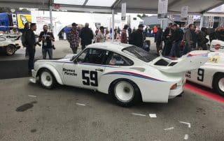 Vintage white Porsche race car at auto event