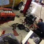 Mechanic repairing engine in auto shop garage