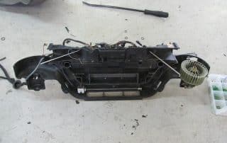 Disassembled car HVAC unit on workshop floor