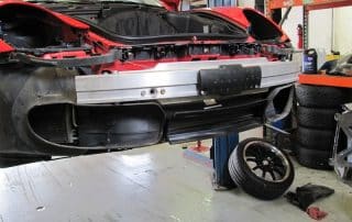 Car with front bumper removed in auto shop