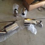 Chrome car exhaust mufflers on garage floor