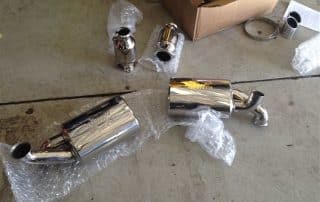 Chrome car exhaust mufflers on garage floor