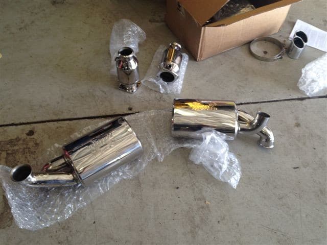 Chrome car exhaust mufflers on garage floor