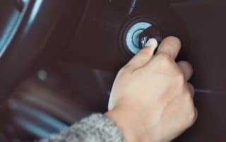 Hand turning car key in ignition