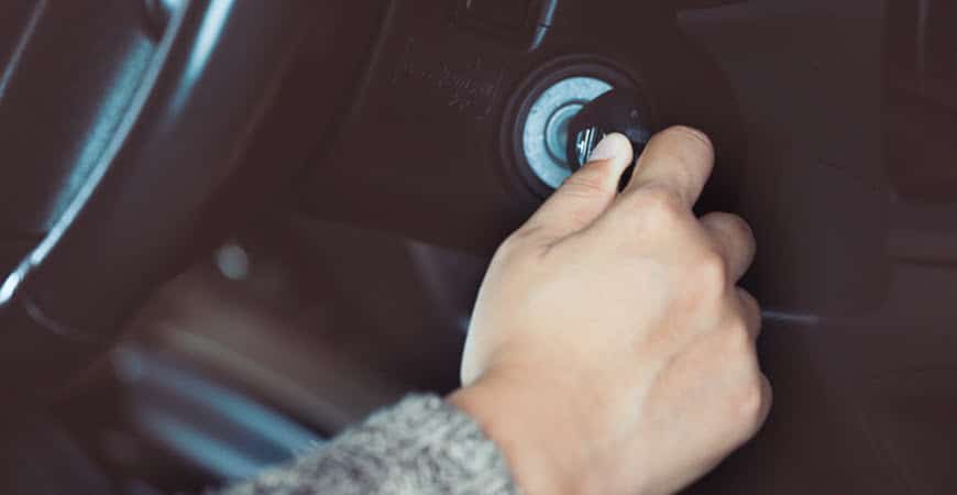Hand turning car key in ignition