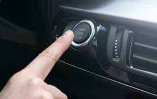 Finger pressing car start stop engine button