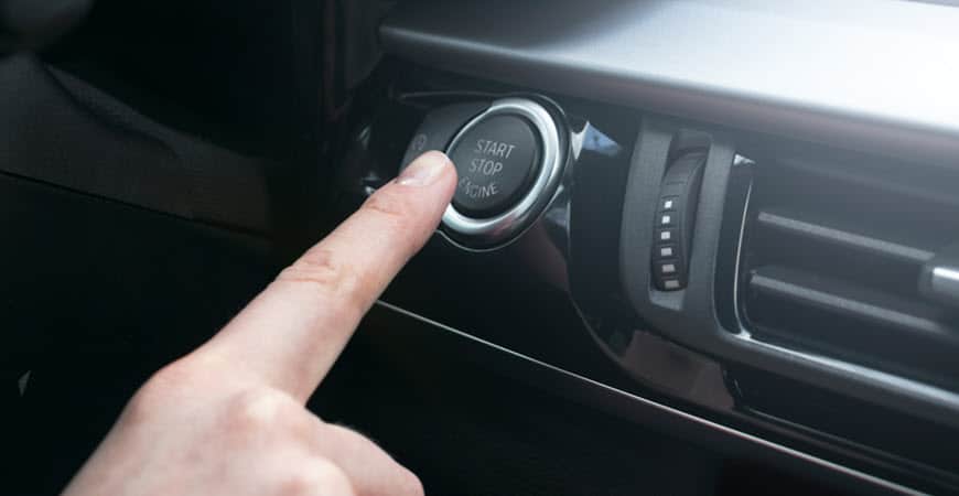 Finger pressing car start stop engine button