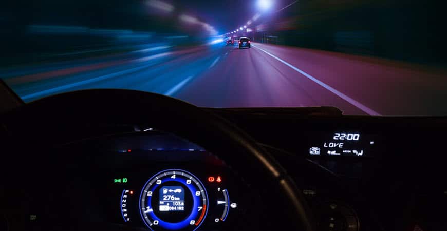 Nighttime highway view from car dashboard