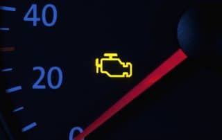 Car dashboard with illuminated check engine light