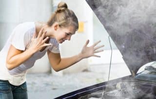 Woman reacting to smoking car engine