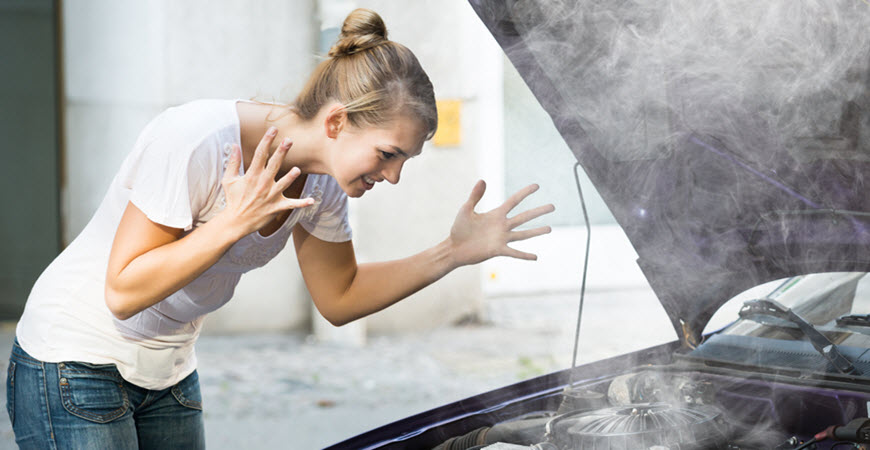 Woman reacting to smoking car engine