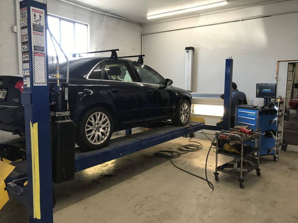 Black sedan on lift in auto shop