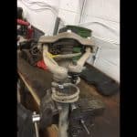Car suspension assembly clamped in bench vise