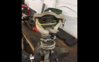 Car suspension assembly clamped in bench vise
