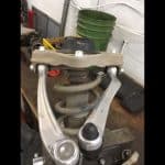 Car suspension assembly with coil spring and control arms