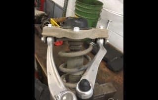 Car suspension assembly with coil spring and control arms