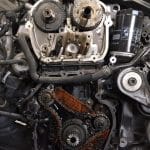Exposed car engine with visible timing chains and gears