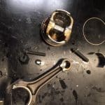 Engine piston and connecting rod on workbench