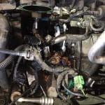 Corroded car engine with exposed hoses and wiring