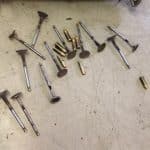Engine valves and small metal parts on workbench