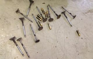 Engine valves and small metal parts on workbench