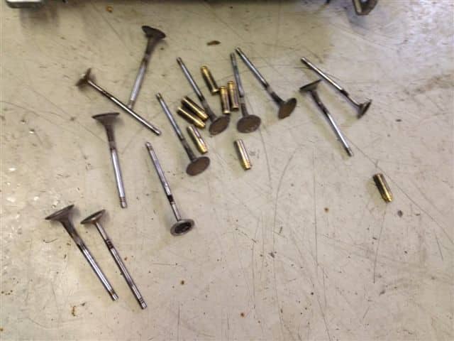 Engine valves and small metal parts on workbench