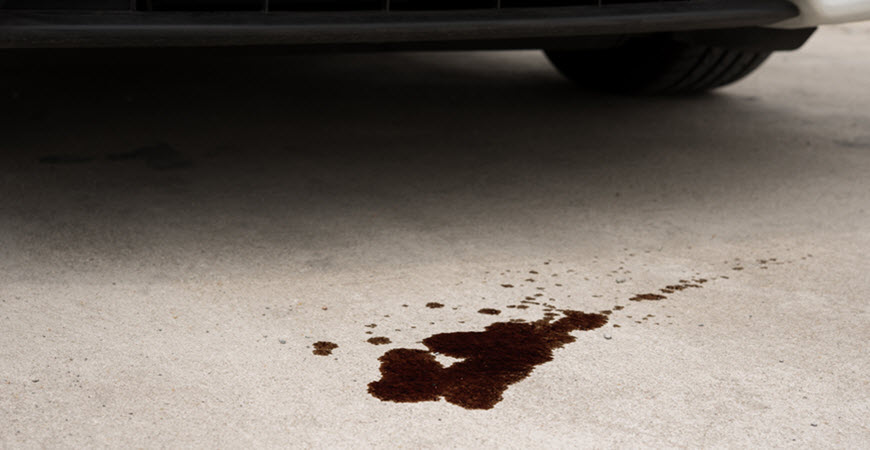 Dark fluid puddle under parked car