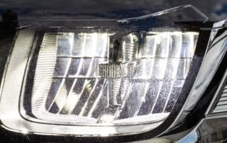 Close-up of modern car headlight with reflections