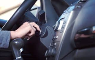 Hand turning car ignition key inside vehicle