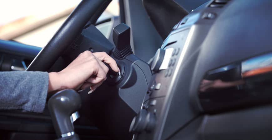 Hand turning car ignition key inside vehicle