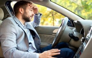 Man looking stressed while sitting in car