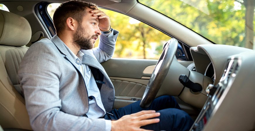 Man looking stressed while sitting in car
